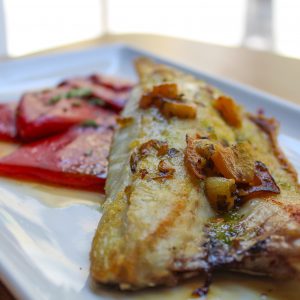 Lubina asada con refrito de ajo y piquillo