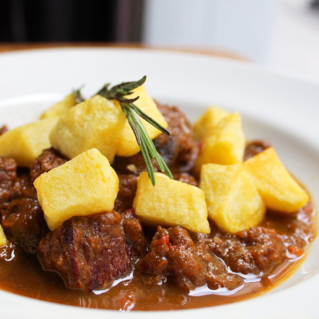 Carrillera de ternera guisada con sus verduras y patatas fritas en dado
