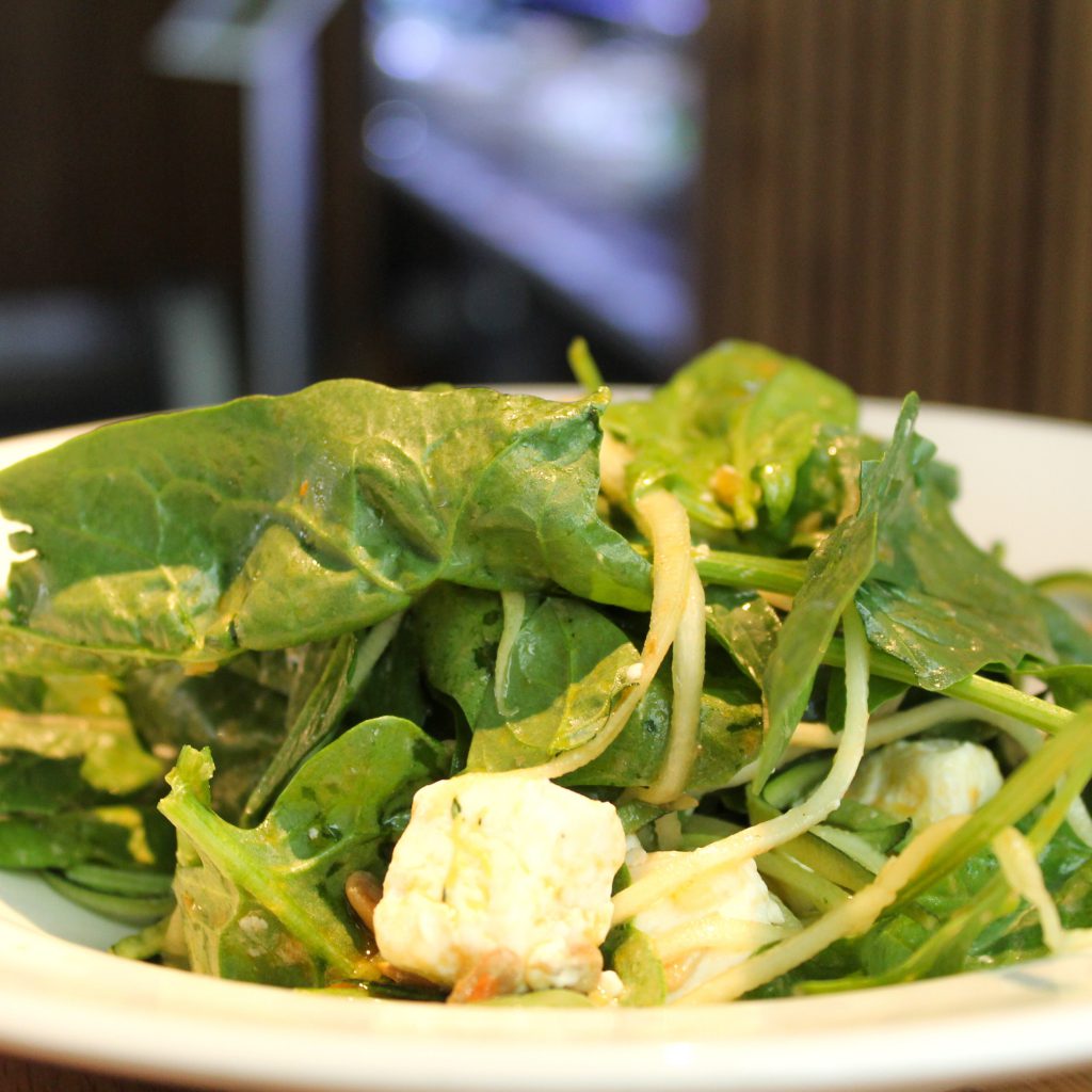 Ensalada de espinacas, tallarines de calabacín, queso de cabra, pipas y vinagreta dulce