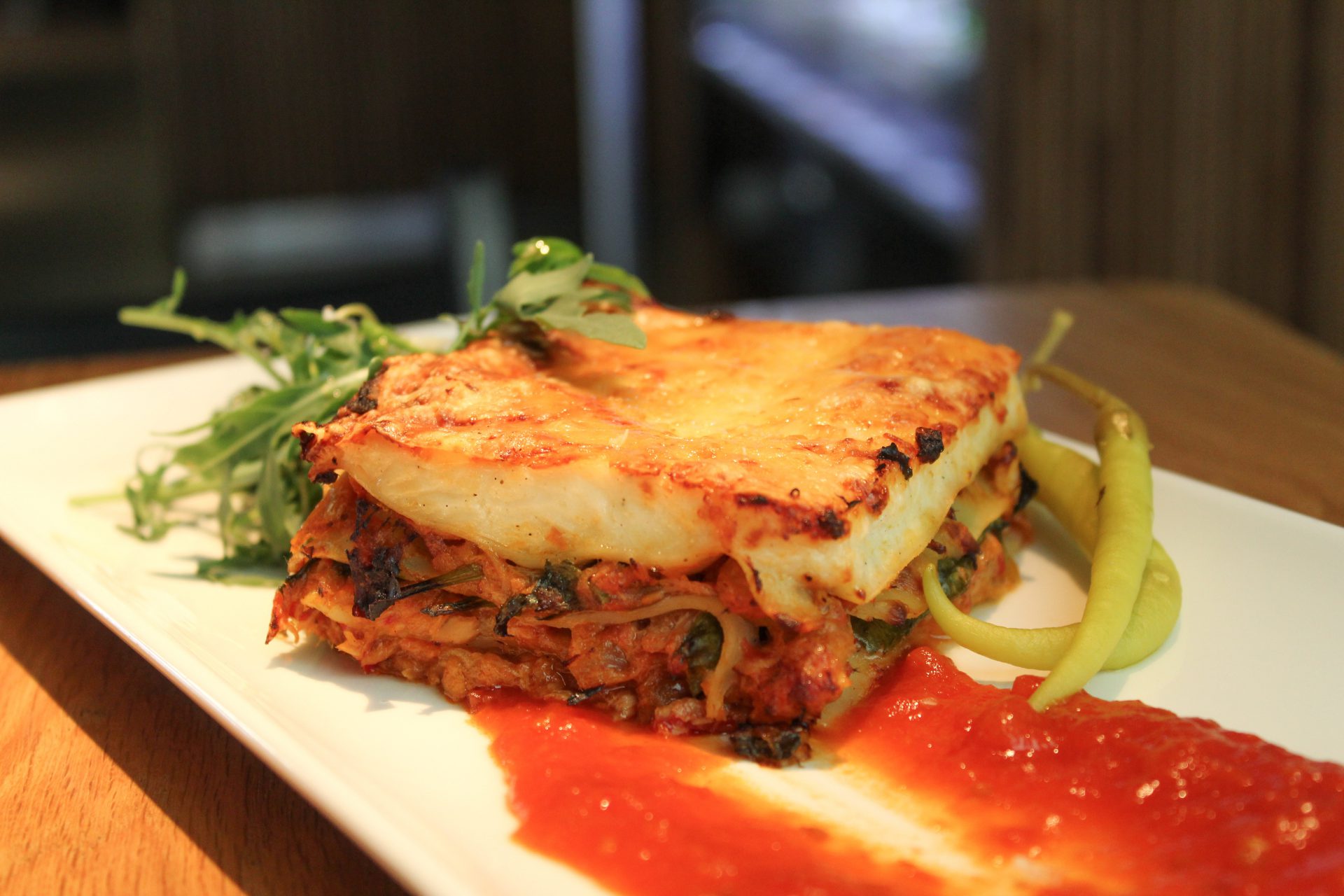 Lasaña de bonito con huevo y piparras con salsa de tomate y brotes verdes Lasaña de bonito con huevo y piparras con salsa de tomate y brotes verdes