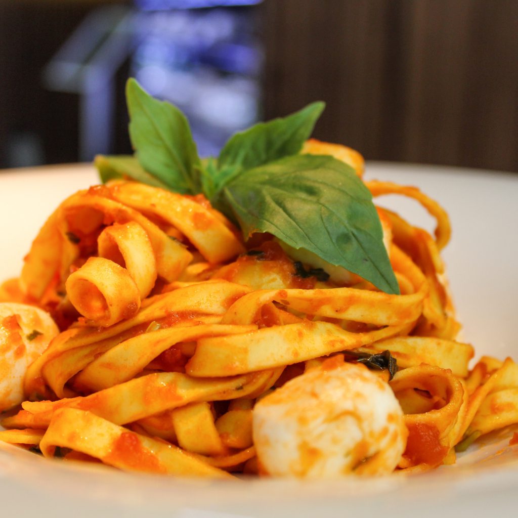 Tagliatelle con salsa de tomate, perlas de mozzarella y albahaca.