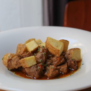 Cerdo guisado a la dominicana al ají con patatas fritas