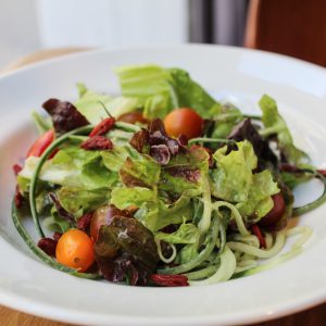 Ensalada de lechuga, pepino bayas goji, tomate cherry con vinagreta de naranja, tahini y vinagre de manzana.