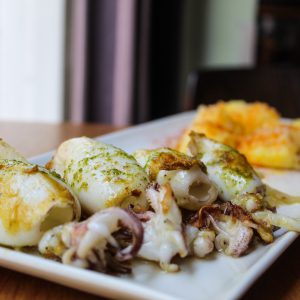 Chipirones al ajillo a la plancha con base de encebollado y patata gallega cocida