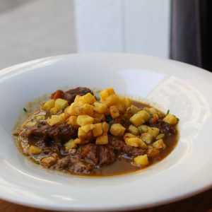 Ragout de ternera con setas y verduras servido con patatas dados fritas