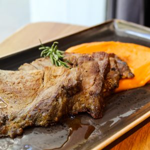 Aguja de cerdo asada marinada con mostaza y hierbas con puré de boniato