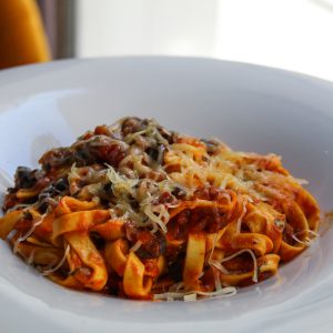 Tagliatelle a la puttanesca con tomate, anchoas, ajo, aceitunas negras y parmesano