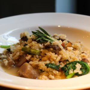 Arroz integral caldoso, con trigueros, setas de otoño y espinacas
