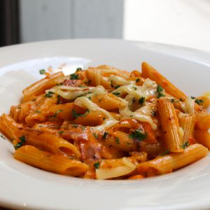 Penne rigatte a la Amatriciana con bacon, salsa de tomate casera, nata, una pizca de Cayena y parmesano rallado