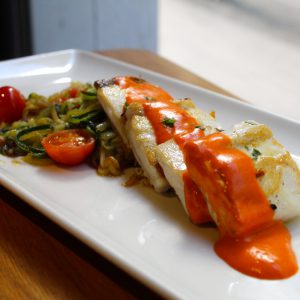 Pez mantequilla a la plancha con tallarín de calabacín y tomate cherry salteado con salsa de piquillos