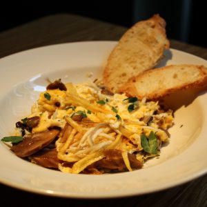 revuelto de gulas y setas de temporada con patata paja